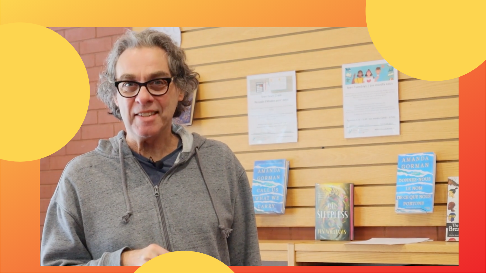 OPL librarian standing in front of a wall of books