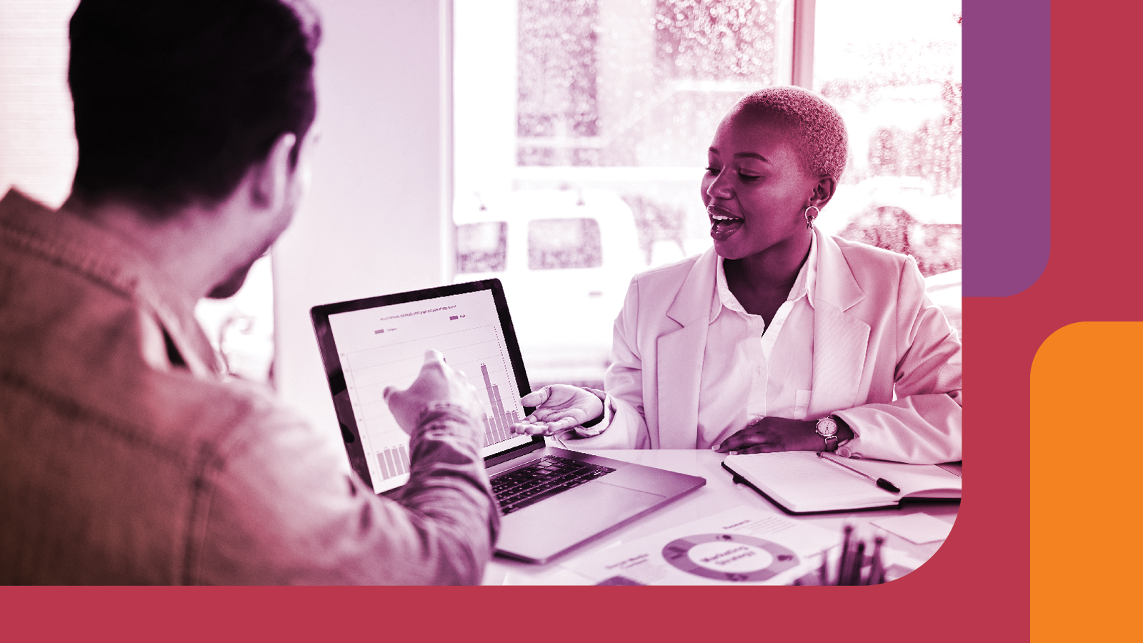 Two people discussing and looking at a laptop screen. 