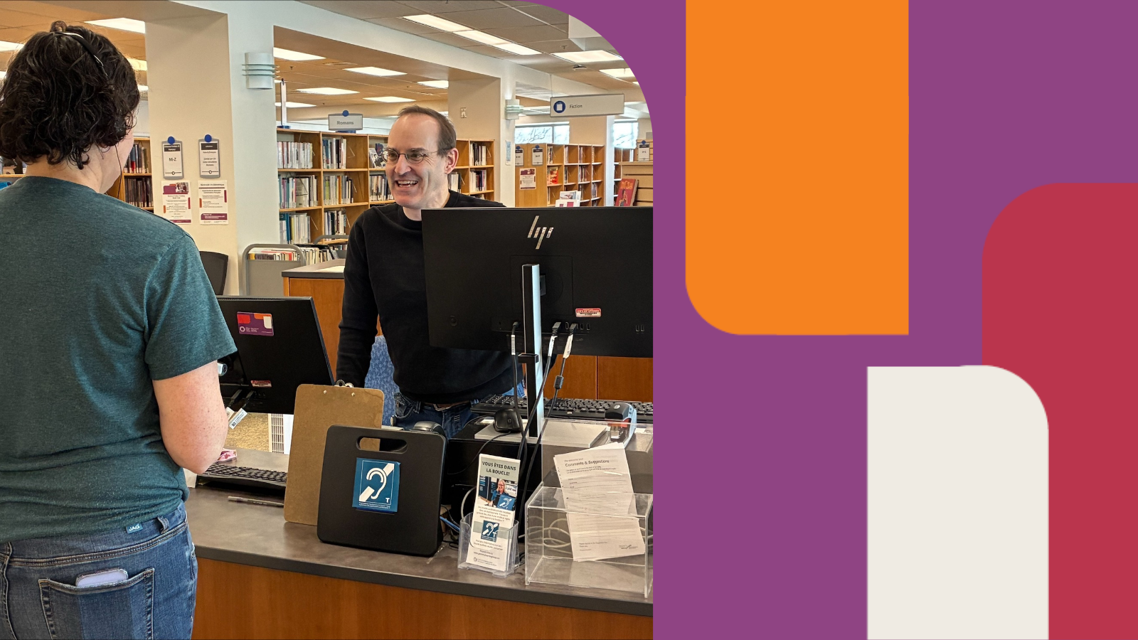 A client wearing a hearing aid headset and talking to the staff member at the front desk.