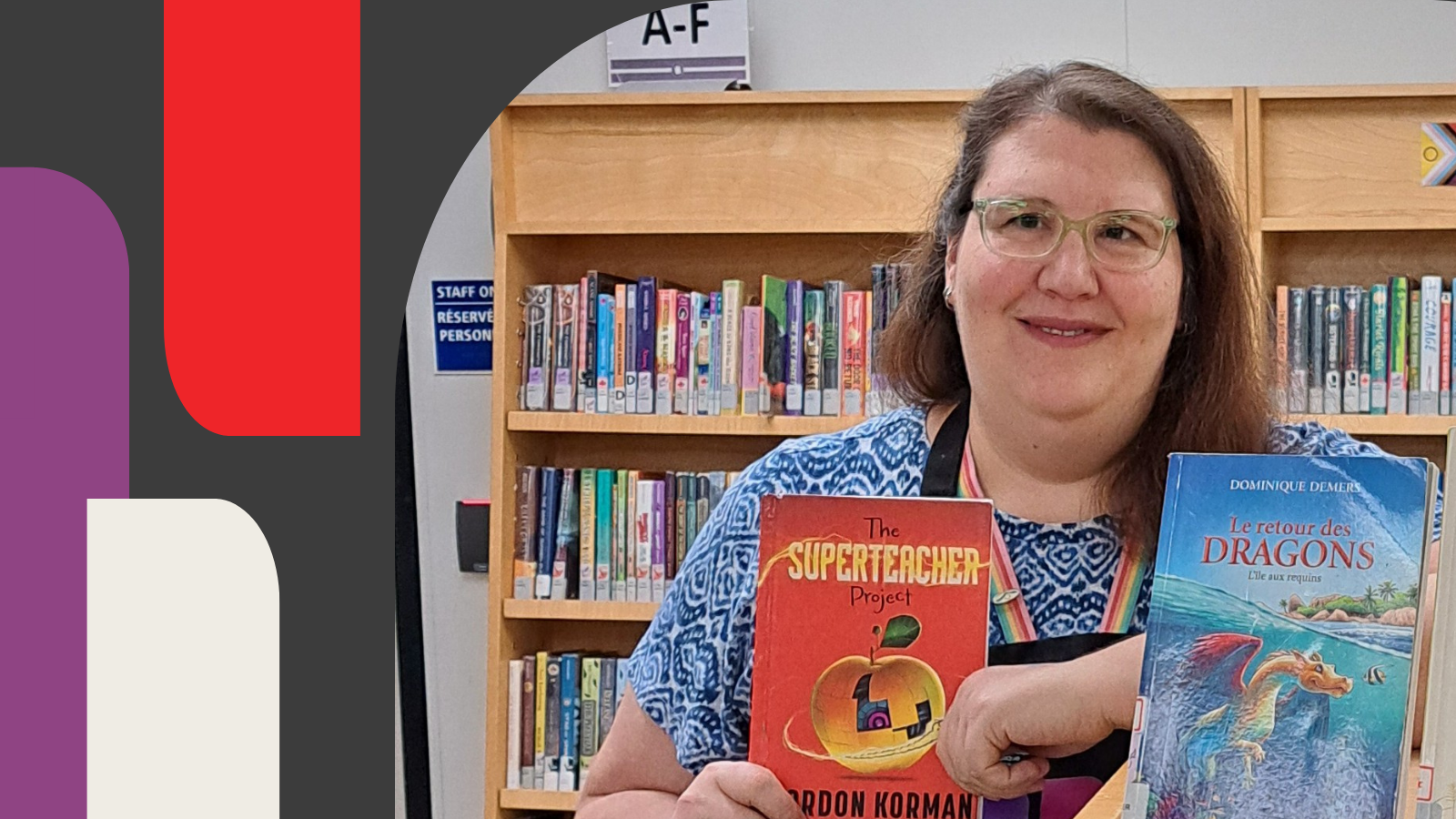 Librarian holding a children's book standing near bookshelf