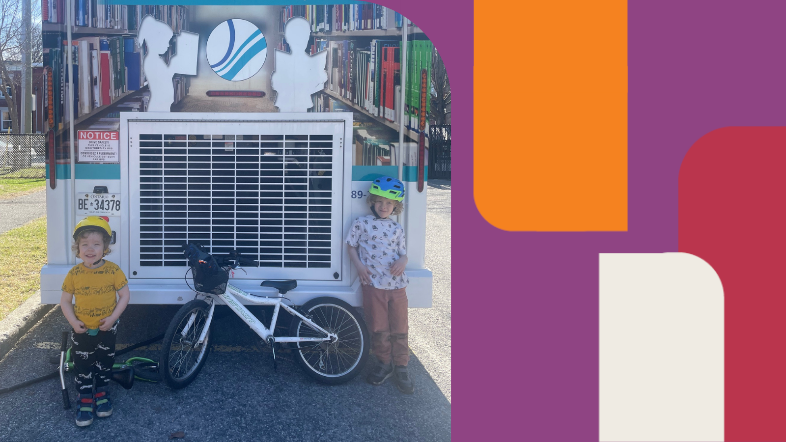 Two kids standing in front of the Bookmobile | Deux enfants devant le Bibliobus